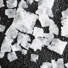 Cristales de sal Maldon, con sus distintivas propiedades y forma piramidal, sobre una superficie oscura.