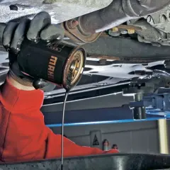 Mechanik wymienia stary olej silnikowy. Pamiętaj, co ile się wymienia olej, by auto służyło latami.