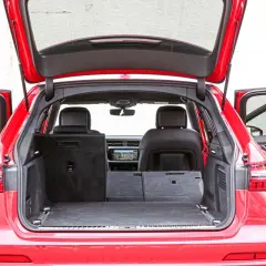 Czerwone Audi A6 Avant z otwartą klapą bagażnika i drzwiami. Wnętrze pokazuje przestronny bagażnik, idealny na wakacyjne wyjazdy, z możliwością powiększenia przestrzeni po złożeniu siedzeń.