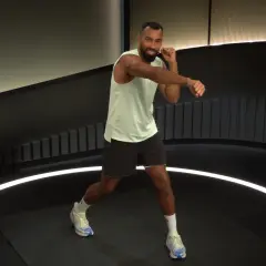 Man in athletic wear throws a powerful cross punch during a workout.