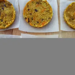 Seis hamburguesas de lentejas caseras, listas para cocinar. Tienen trocitos de zanahoria y cebolla morada.