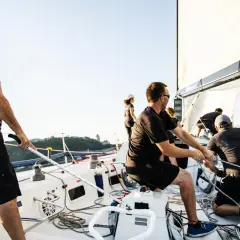 Equipaggio su una barca a vela, intenti a tirare le cime. Il **lasciare significato** è nel lavoro di squadra per navigare.