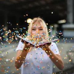 Blondynka dmucha w otwartą książkę, rozsypując kolorowy konfetti. To jakby każda strona tej serii twisted po kolei otwierała nowy, barwny świat.
