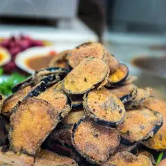 Un tas de beignets d'aubergine dorés et croustillants, prêts à être dégustés.