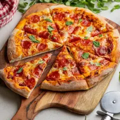 Pyszna pizza salami z ciągnącym serem i świeżą bazylią, pokrojona na kawałki, czeka na spróbowanie.
