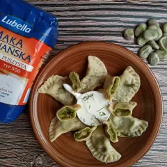 Pyszne pierogi z bobem, podane z kwaśną śmietaną i koperkiem, obok mąki Lubella.