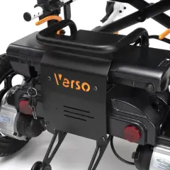 Zbliżenie na czarny wózek inwalidzki elektryczny z pomarańczowym logo "Verso" i kluczykami.