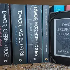 Na półce stoją książki z serii **Dwór Cierni i Róż** autorstwa Sarah J. Maas, obok e-czytnik z okładką "Dwór Srebrnych Płomieni".