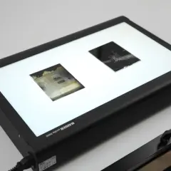 Dwa stare zdjęcia naświetlane na jasnej płycie, przygotowane do digitalizacji.