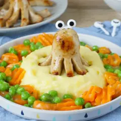 Kreative proteinreiche Rezepte: Wurst-Oktopus auf Kartoffelbrei mit Erbsen und Karotten. Ein lustiges Gericht für Kinder.