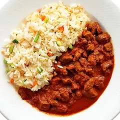 En portion ungersk gulasch med ris och grönsaker. Köttet är mört och såsen rik.