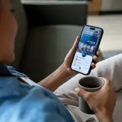 Kobieta sprawdza saldo księgowe na telefonie, widoczny dostępny bilans $1,730.50.