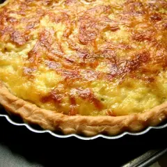 Une quiche aux poireaux dorée et appétissante, avec une croûte croustillante et une garniture crémeuse. Parfaite pour un repas réconfortant.