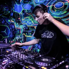Młody DJ w słuchawkach miksuje muzykę w klubie z psychodelicznym tłem. Chcesz wiedzieć, jak zostać DJ w klubie? Zacznij od tego!
