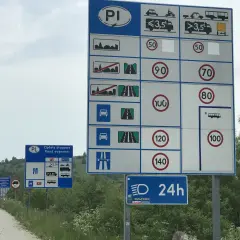 Znaki drogowe informujące o opłatach i ograniczeniach prędkości. Przygotuj się na jazdę w terenie zabudowanym i poza nim.