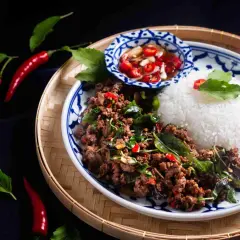 En portion pad kra pao med ris, chilipickles och färska chilifrukter.