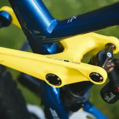 Żółte ramię korby z napisem "PRO LEVER 180MM" na tle niebieskiej ramy roweru.