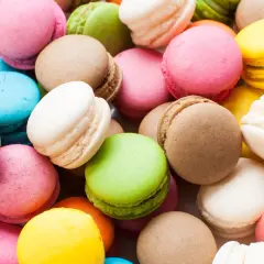 Montón de macarons de colores: rosa, verde, amarillo, azul, blanco y marrón. Estos dulces, de donde son los macarons, son un deleite visual y gustativo.