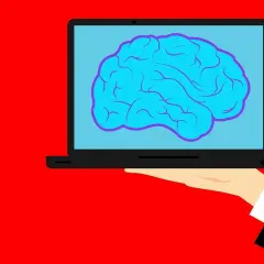 Dłoń trzyma laptop z mózgiem na ekranie. Czy po udarze przysługuje renta? Szukamy odpowiedzi.