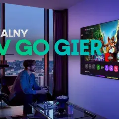 Idealny TV do gier z adaptive sync. Mężczyzna gra w gry na dużym ekranie w nowoczesnym salonie.