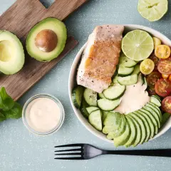 En härlig keto recept-bowl med lax, avokado, gurka, tomater och en krämig dressing. Perfekt för en hälsosam lunch.