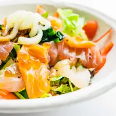 Deliziosa insalata di mare con verdure fresche, salmone affumicato, gamberi e uova di pesce, un tripudio di sapori e colori.