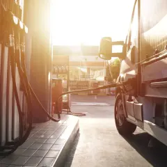 Lastenbilen tankas med diesel i solnedgången. En gammal dieselmotor behöver sin energi.