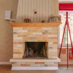Ein Kamin aus Sandstein, der gereinigt wurde, mit Holzverkleidung und Dekorationen.