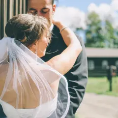 Para młoda w objęciach, zasłonięta welonem. Czy to ślub cywilny, czy kościelny, miłość jest najważniejsza.