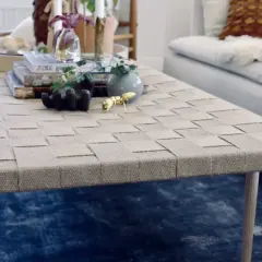 Ett vackert diy soffbord med flätad topp och träben. Prydnader som en guldfärgad myra och en liten vas ger liv åt bordet.