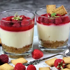Zwei leckere Desserts im Glas mit Himbeeren und Keksen, ein süßer Genuss für jeden Anlass.