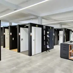 Salon z drzwiami i oknami, prezentujący różne modele drzwi wewnętrznych i zewnętrznych.