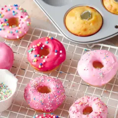 Deliciosos donuts rosados y brillantes, listos para decorar. Una tentadora receta de donuts para disfrutar.