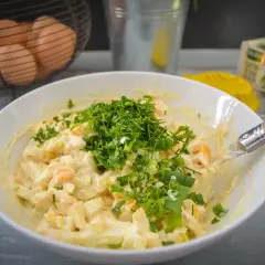 Cremiger eiersalat mit schmand, garniert mit frischen Kräutern und Frühlingszwiebeln. Perfekt für ein leichtes Mittagessen.