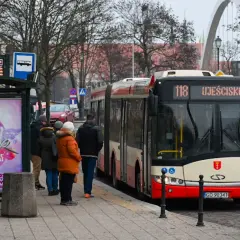 Autobus linii 118 Ujeścisko czeka na przystanku w Gdańsku. Ludzie czekają na zimowy dzień.