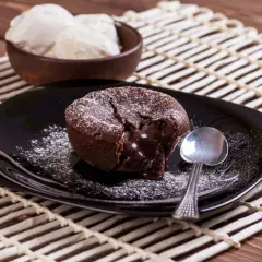 Un délicieux moelleux au chocolat, cœur coulant, saupoudré de sucre glace, servi avec de la glace à la vanille. Une recette gourmande à tester !
