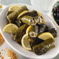 Gefüllte Weinblätter, ein köstliches Dolmades Rezept, serviert mit Zitronenspalten und Oliven.