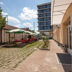 Letni dzień w kawiarni przy budapest nepliget. Stoliki pod parasolami, ludzie odpoczywają.