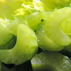Chrupiące kawałki selera naciowego, idealne do jedzenia na surowo. Woda lśni na zielonych łodyżkach.