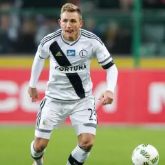 Kuba Rzeźniczak w akcji na boisku, w białej koszulce z czarnymi pasami i numerem 29.