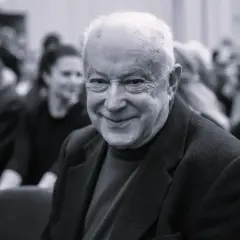 Uśmiechnięty starszy pan, być może syn Alicji Bobrowskiej, w otoczeniu ludzi.