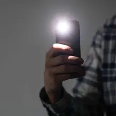 Dłoń trzyma smartfon Samsung, którego lampa błyskowa świeci. Zastanawiasz się, dlaczego nie działa lampa błyskowa w aparacie Samsung?