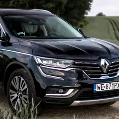 Czarny Renault Initiale na tle zielonych pól. Elegancki SUV z chromowanymi detalami i nowoczesnymi światłami.