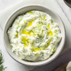 En skål med krämig kall sås med gurka och dill, toppad med olivolja. Perfekt till grillat!