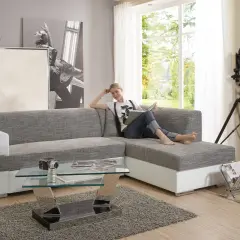 Ein modernes Wohnzimmer mit einer Frau auf dem Sofa, die liest. Der Glastisch davor ist nicht sehr hoch, perfekt für Snacks.