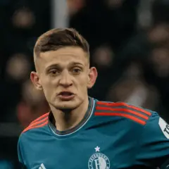 Młody piłkarz w niebieskiej koszulce z czerwonymi pasami na ramionach, z emblematem Feyenoordu. Czy to **kitman, kto to**?