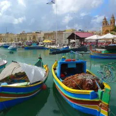 Kolorowe łodzie rybackie w Marsaxlokk, Malta. Ceny pamiątek i jedzenia mogą się różnić, ale widok jest bezcenny.