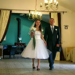 Para młoda idzie do ołtarza. Suknia panny młodej przypomina styl wesele lata 80.