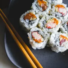 Talerz z sushi, pałeczki i dodatki. Zastanawiasz się nad sushi kcal? Smacznego!