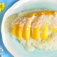 Słodki ryż kleisty z kawałkami mango i wiórkami kokosowymi, polany kremowym sosem. Pyszny deser mango sticky rice.